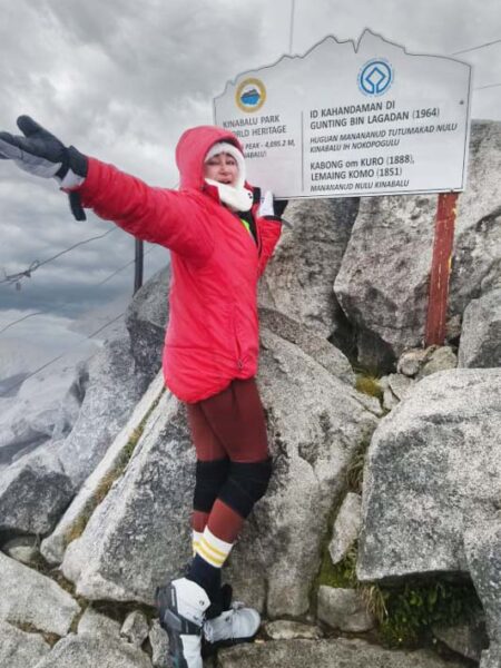 Unstoppable Spirit: Conquering New Heights – Despite the cold and challenging terrain, Puan Sri Nisa fearlessly takes on Mount Kinabalu, proving that strength and determination know no bounds.